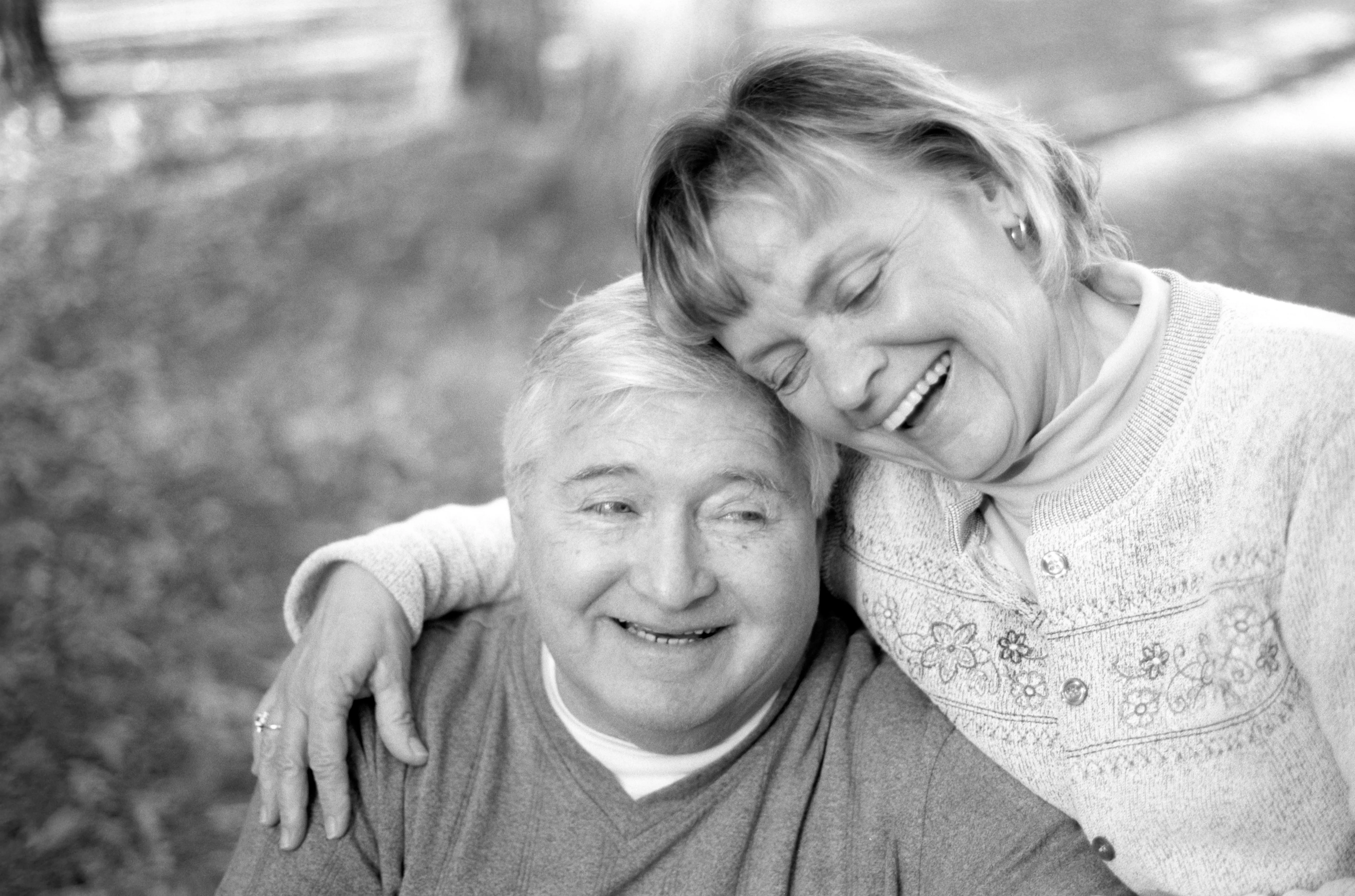 Brenda and Michael cheek to cheek, both laughing. Black and white.