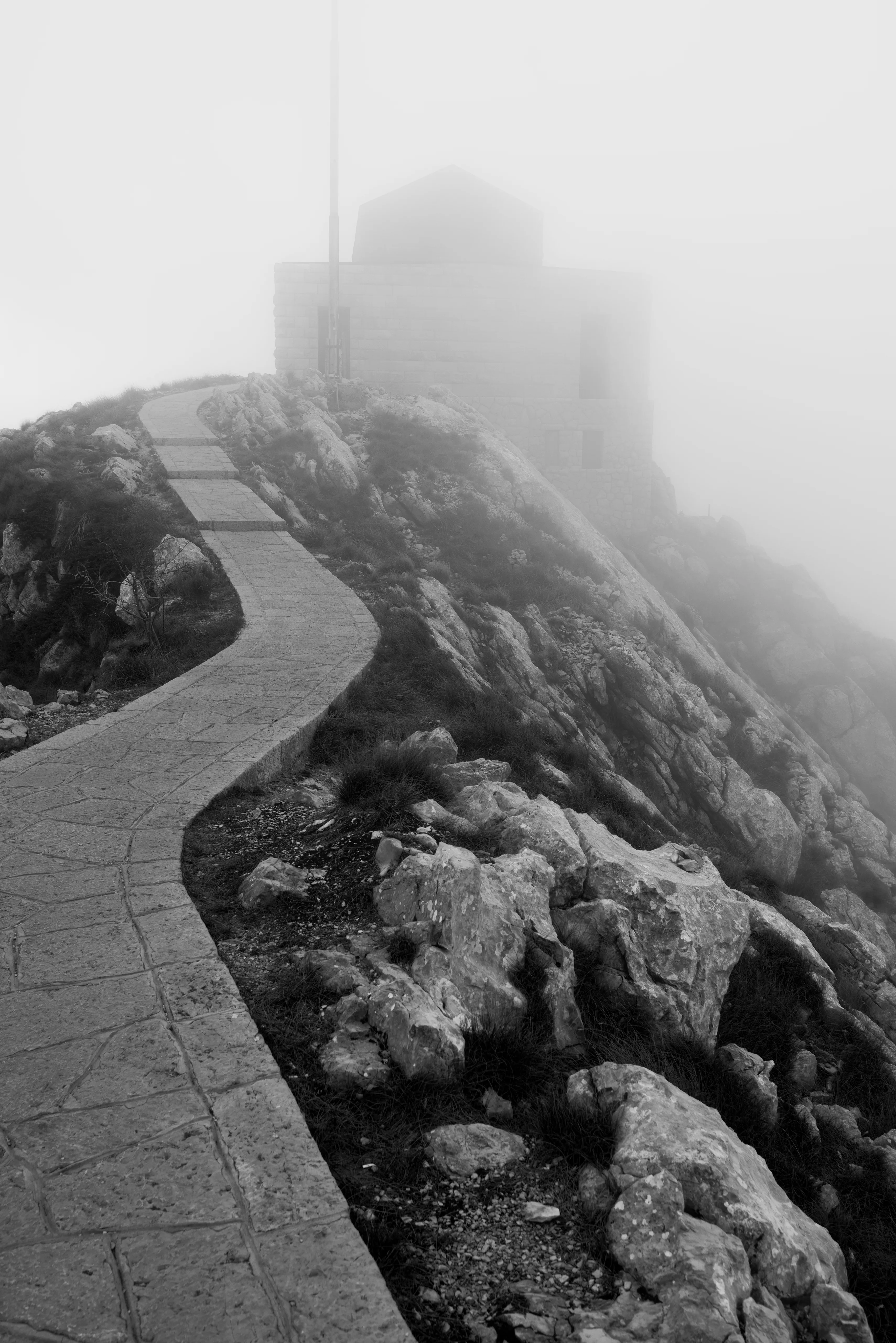 Stone architecture standing in mist; another country half-resolving.