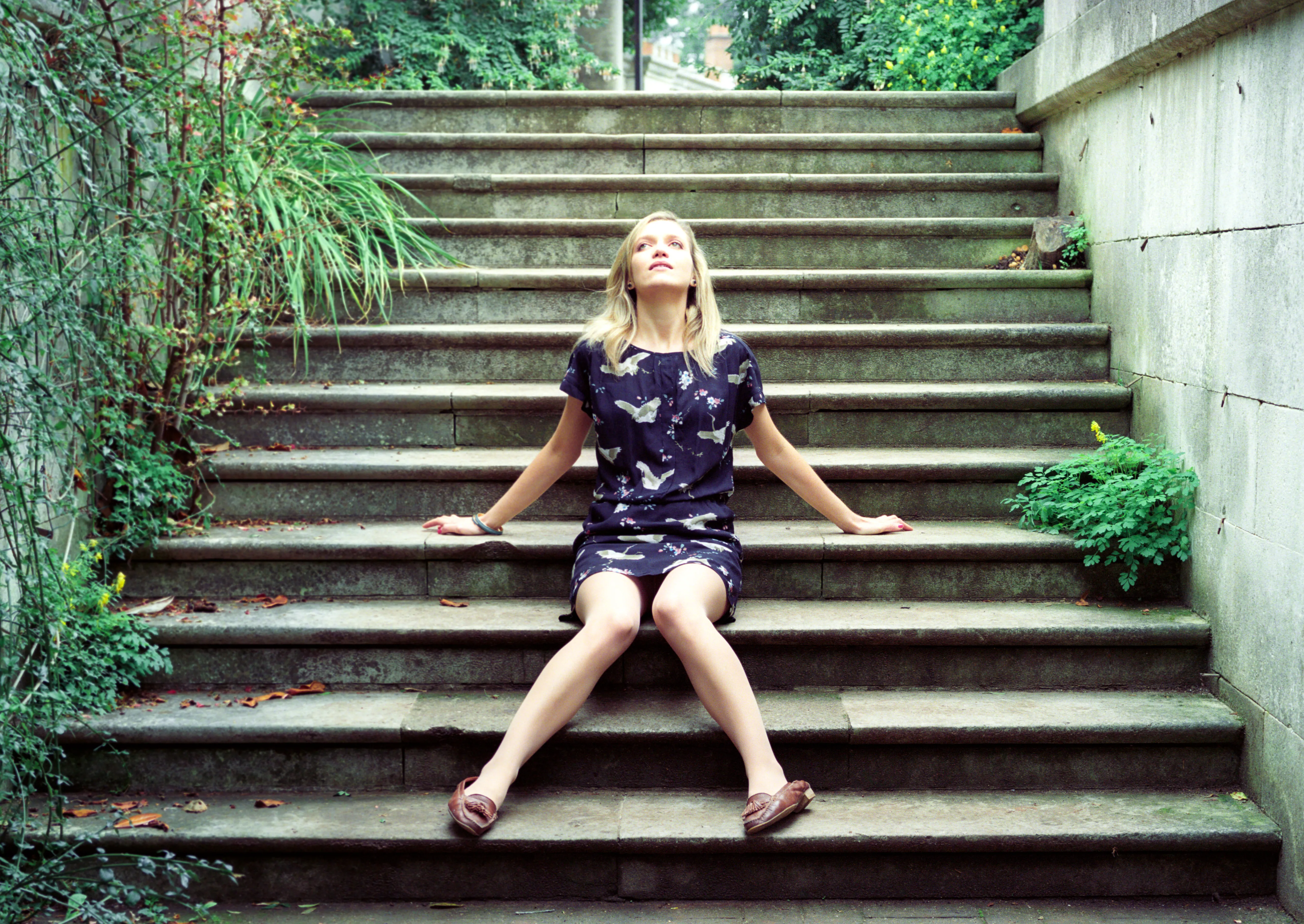 Hannah seated on the same steps, head tipped back with her face to the sky.
