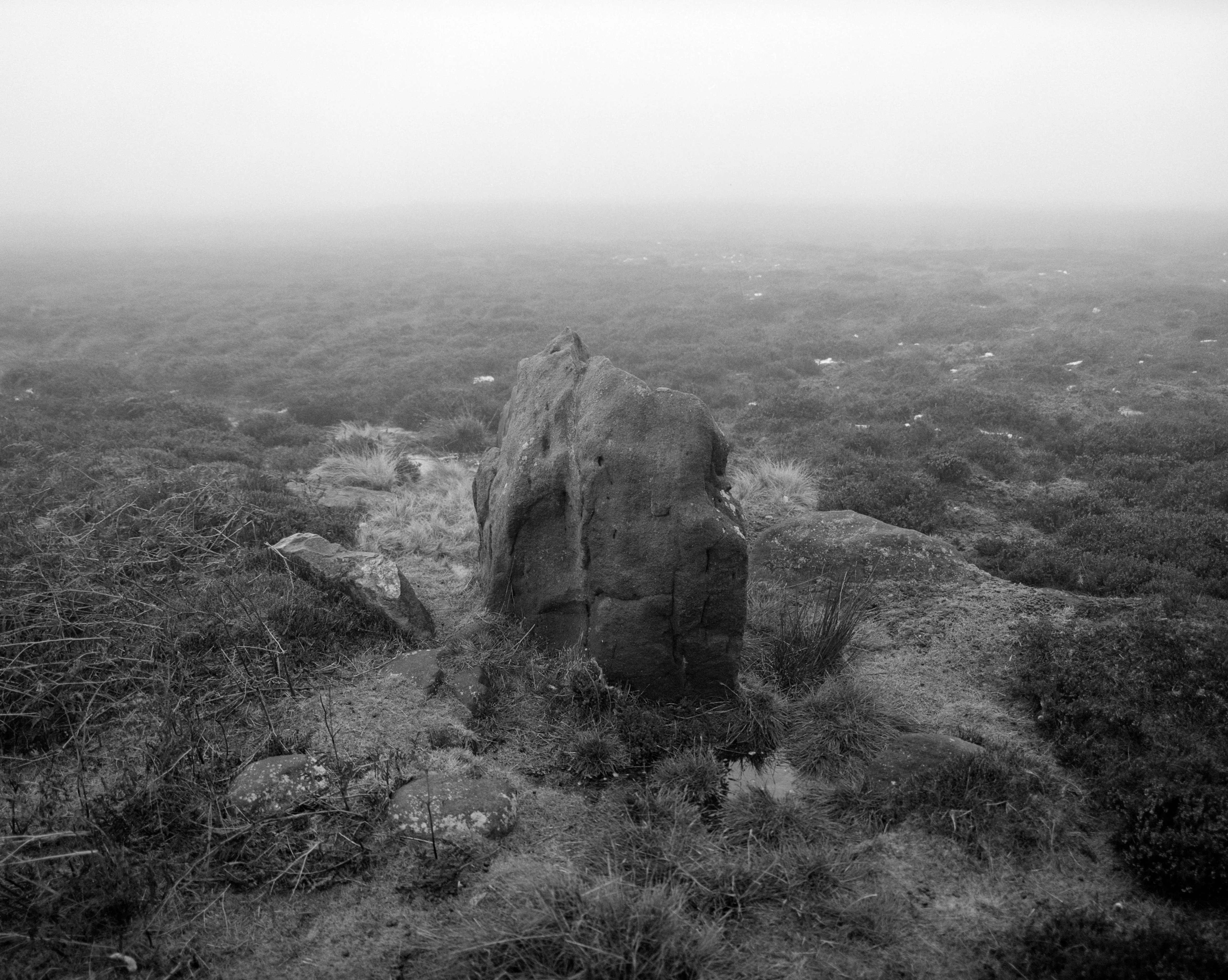 A single standing stone held quiet in pale mist.