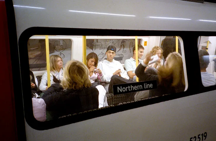 Advertising hoardings sliding past along a London Underground platform.