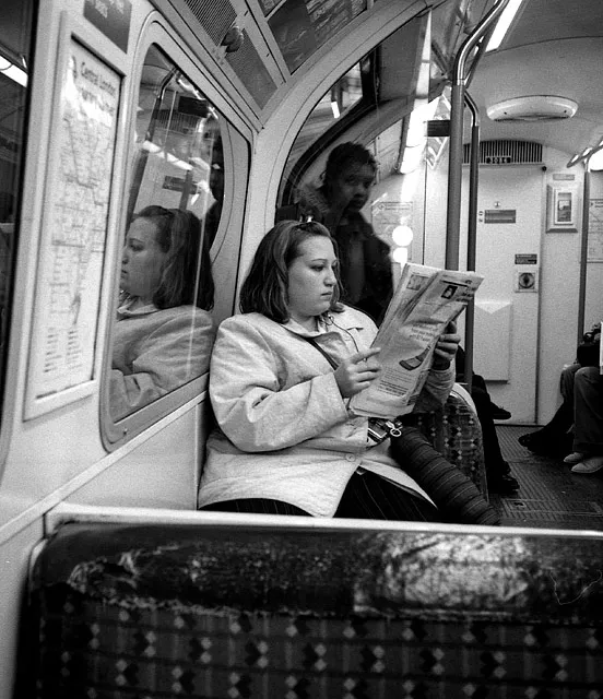 A commuter reading the same free newspaper as everyone else on the Underground.