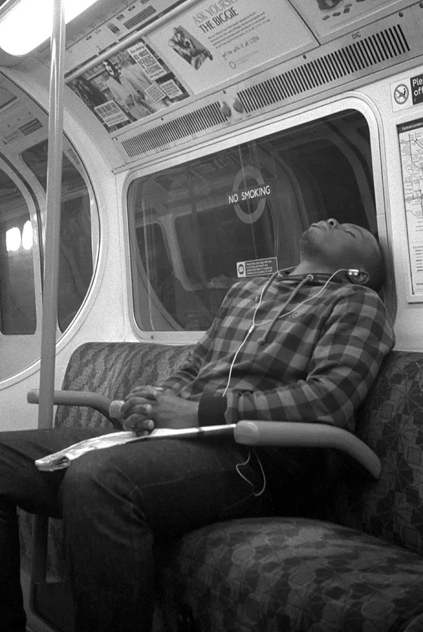 A tired passenger slumped on the London Underground at the end of the day.