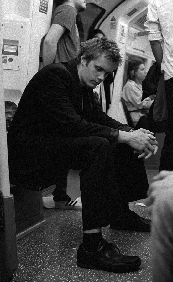 A traveller pausing for a quiet moment amid the Underground's traffic.
