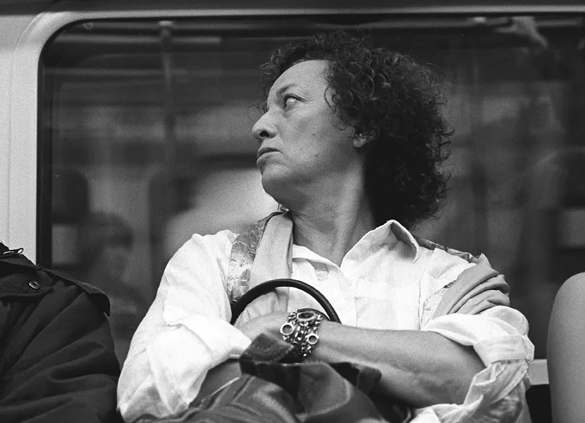Passengers on the opposite platform of a London Underground station, across the tracks.