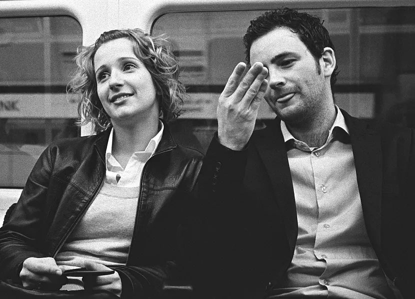 A passenger's attention drawn to something across the London Underground platform.