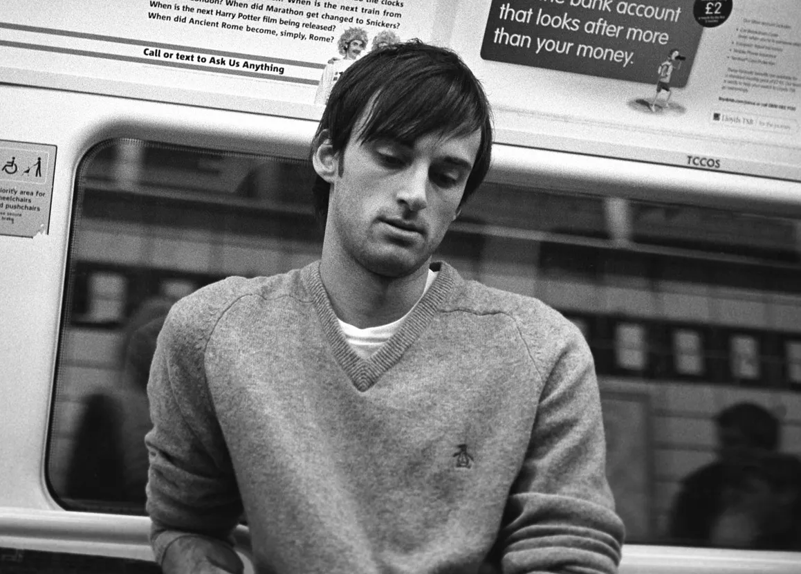 A traveller watching the indicator board on the Underground, waiting for the when.